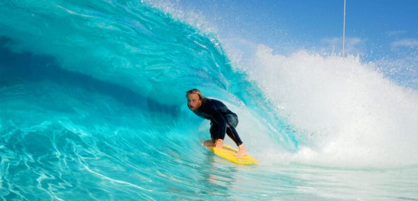 A surfer at Cannon Beach in Mesa, AZ is surfing on a wave.