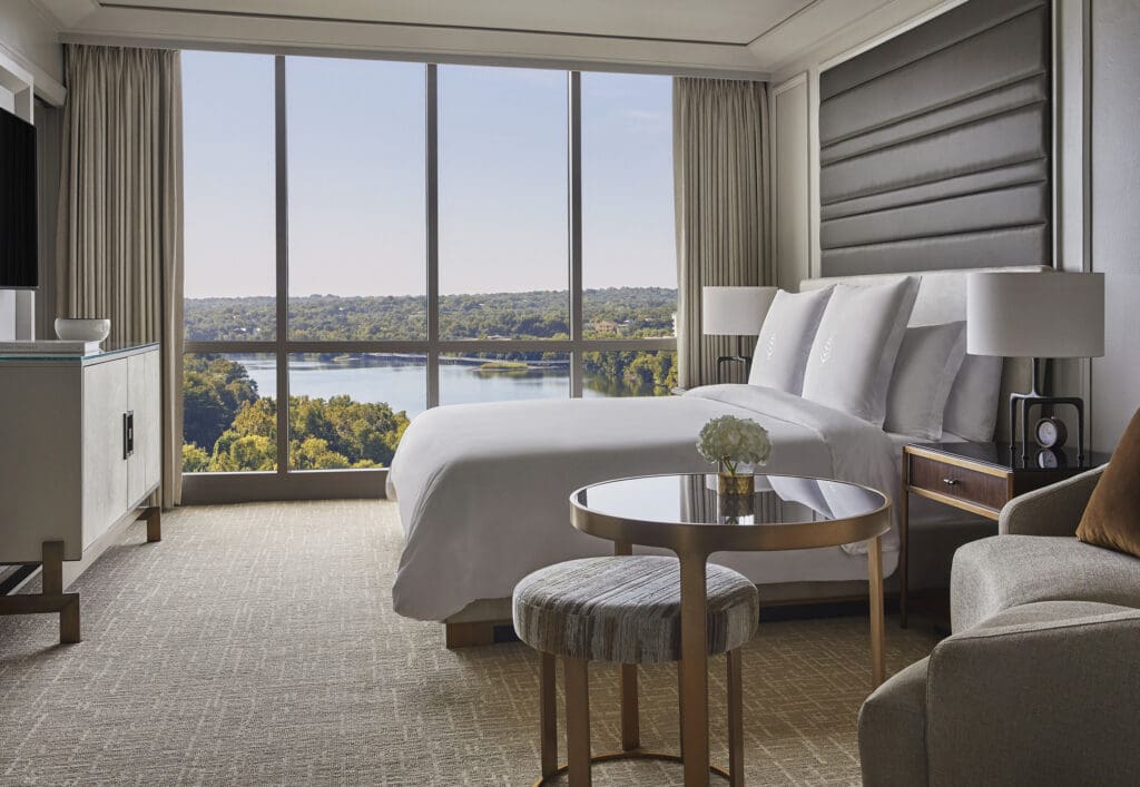 A newly renovated room with bed table and sofa, overlooking the lake at Four Seasons Hotel Austin.