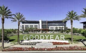 A view of Goodyear GSQ's Goodyear City Hall surrounded by palm trees and flowers.