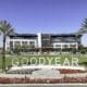A view of Goodyear GSQ's Goodyear City Hall surrounded by palm trees and flowers.