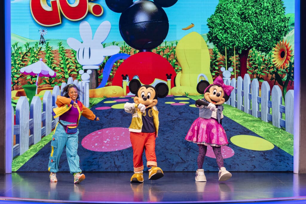 An MC, Mickey Mouse and Minne Mouse dance on stage at the Live Mickey Mouse Clubhouse Jr. show at Disney California Adventure Park.