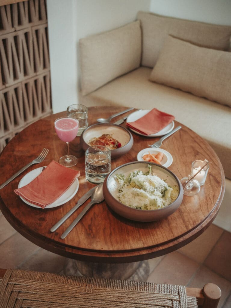 A round table with two plate settings and two culinary dishes at Juliette restaurant at Hotel Willa.