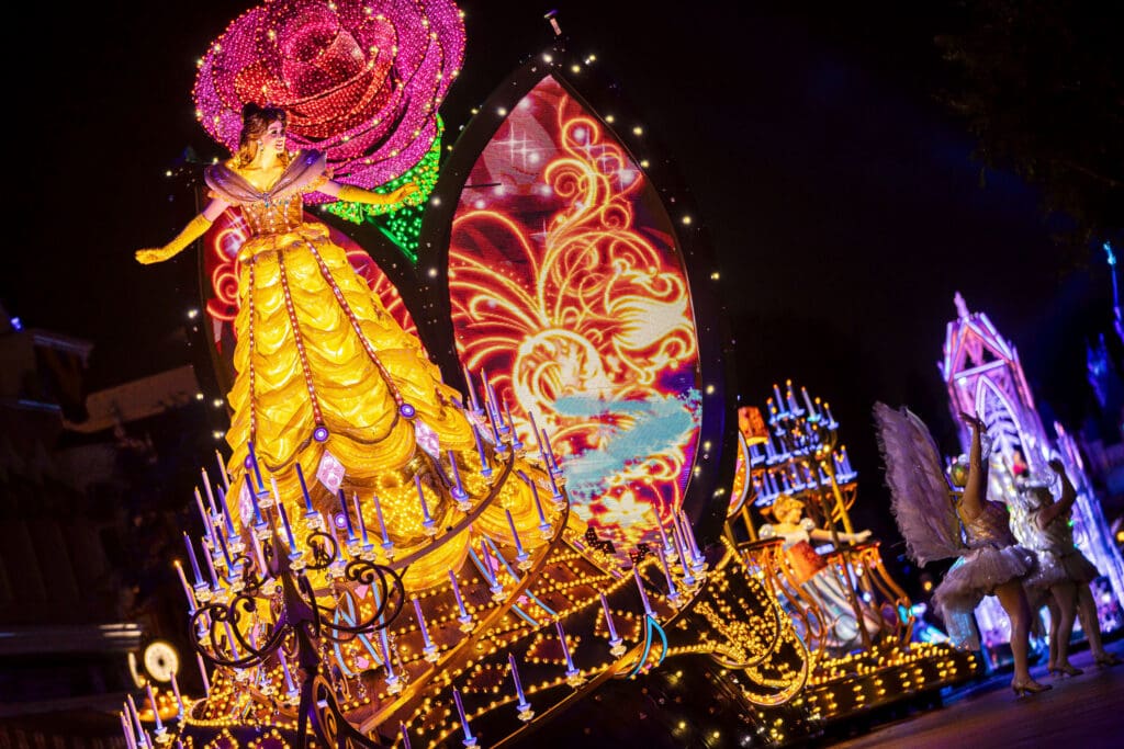 A LED lit Belle towers above guests on a float at Disney Resort's 70th Anniversary "Paint the Night" parade.