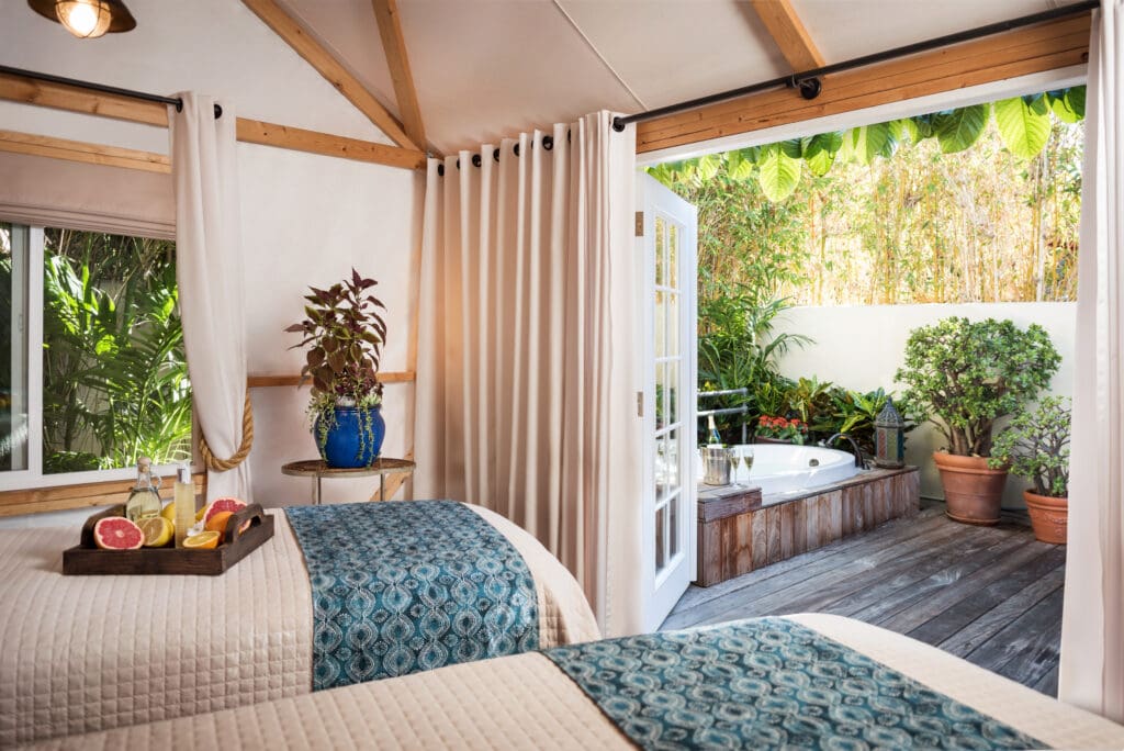 Two couples' spa tables at Spa Estancia with an amenity tray on one.