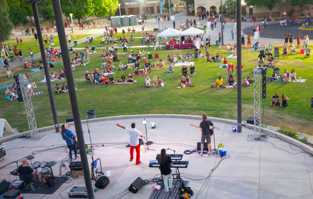 A crowd assembles for Fourth of July in Arizona in Chandler's Downtown with a band playing on a stage.