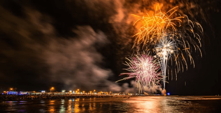Fourth of July in Galveston featuring fireworks over the water with the city in the background.