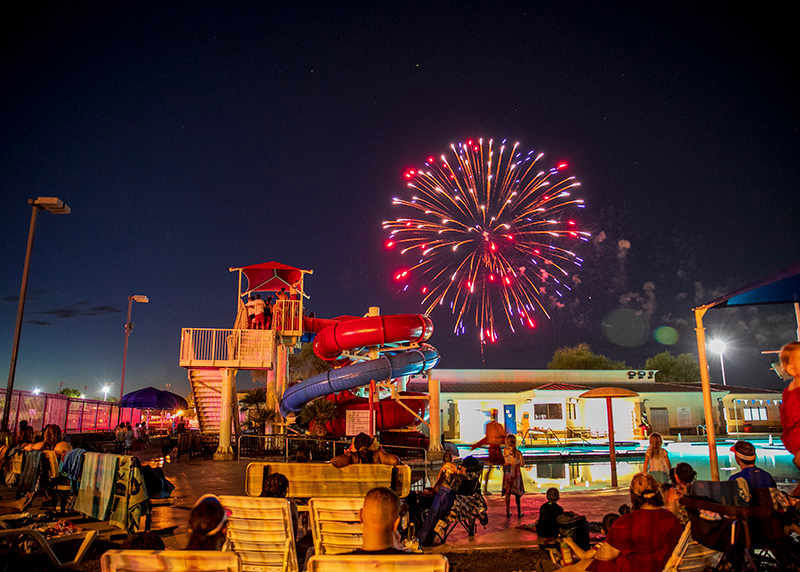 Fireworks above a slide and pool in City of Surprise for the Fourth of July.
