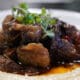 A plate of Oxtail on grits made by Dana Dumas for SugarJam The Southern Kitchen's Juneteenth menu.