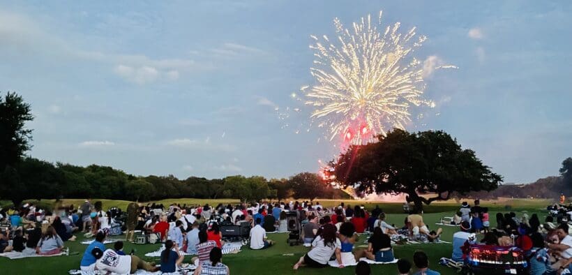 Guests of the Hyatt Regency Hill Country Resort and Spa sit on the property's lawn watching fireworks.