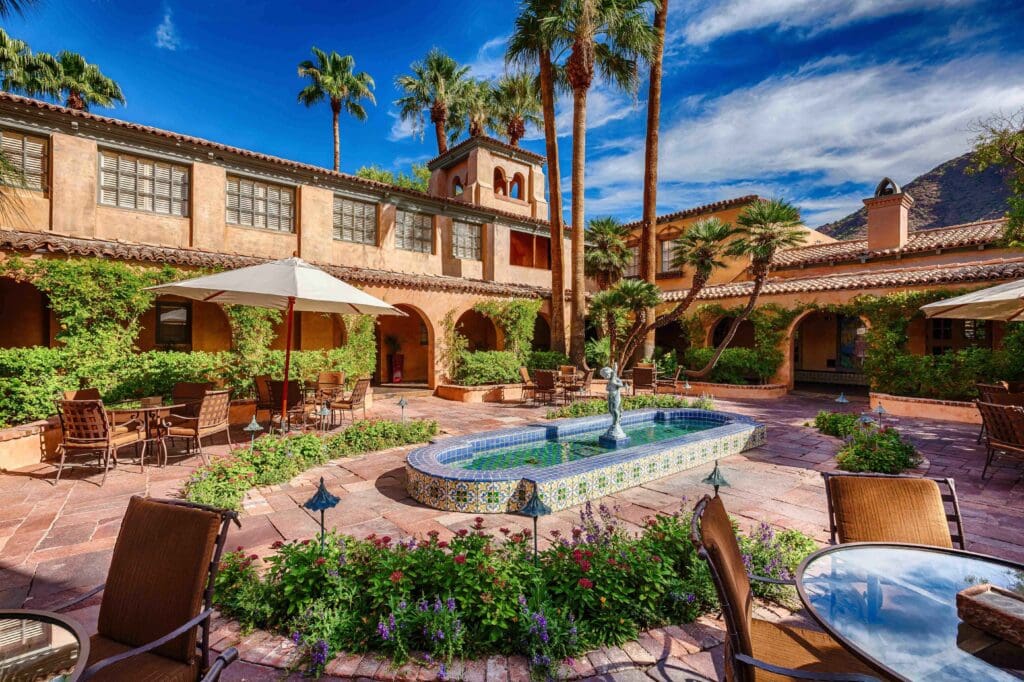 The courtyard of Royal Palms Resort and Spa with a fountain and outdoor seating.
