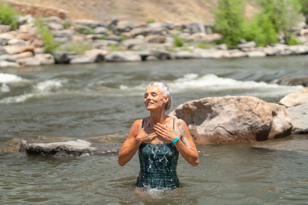 A woman rinses off mineral-rich bentonite clay from the Mojave Desert in the San Juan River at The Springs Resort.