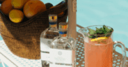A basket of oranges sits next to two bottles of LALO and a pitcher of grapefruit juice for Club Soleil pop up at the The Global Ambassador.