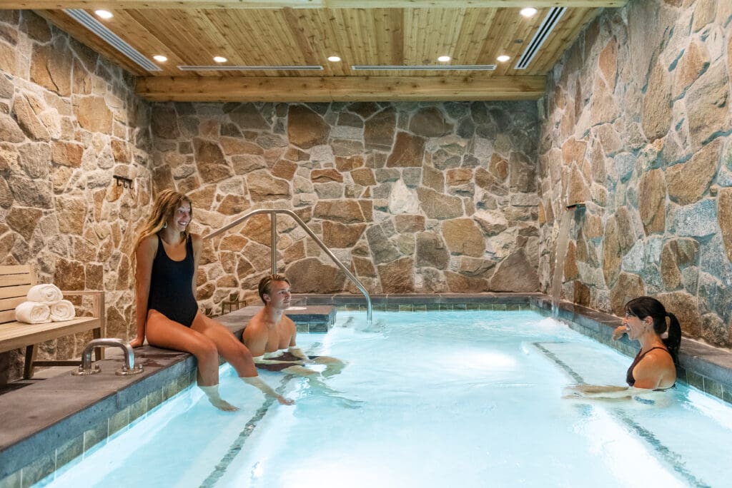 An indoor pool with two women and a man at Snowpine Lodge in Alta Utah.