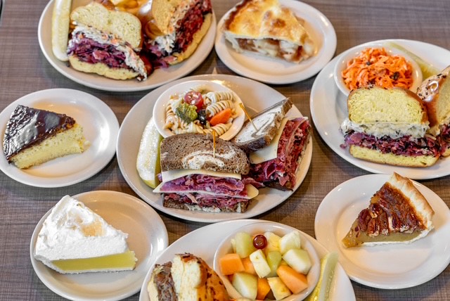 A table full of sandwiches and pies at Miracle Mile Deli.