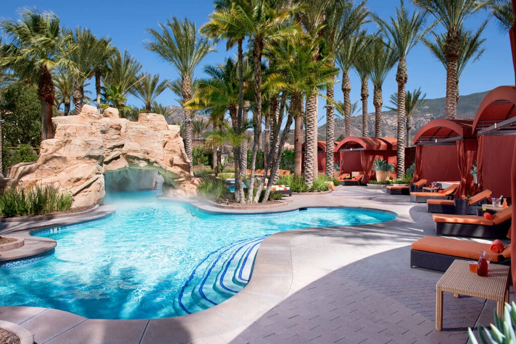 A photo of a small pool with water fall rock formation and luxe cabanas at Harrah's Resort Southern California.