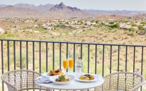 Three plates of food and two mimosa glasses on an outdoor table at CIELO at ADERO Scottsdale.