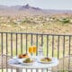 Three plates of food and two mimosa glasses on an outdoor table at CIELO at ADERO Scottsdale.