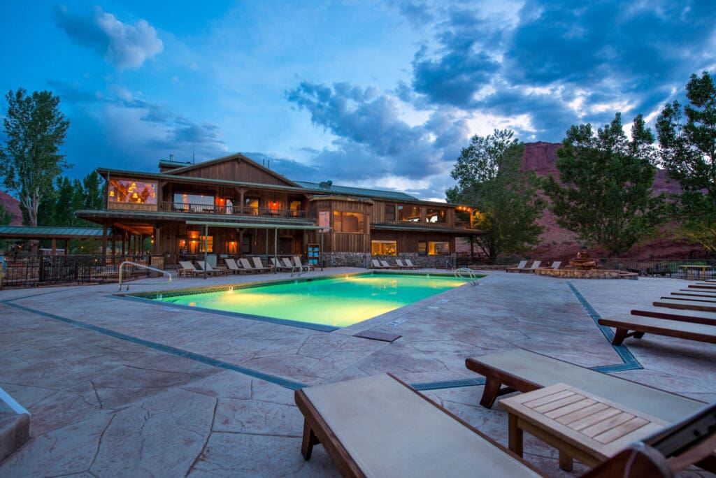 The Sorrel River Ranch Resort & Spa in Moab at dusk, surrounded by lounge chairs.