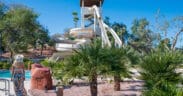 A woman walks toward the Arizona Grand Resort's Oasis Water Park Slide.