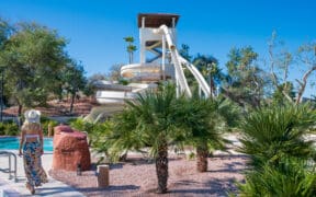 A woman walks toward the Arizona Grand Resort's Oasis Water Park Slide.