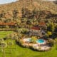 An aerial view of Castle Hot Springs Resort with main lodging and pool set near the mountains.