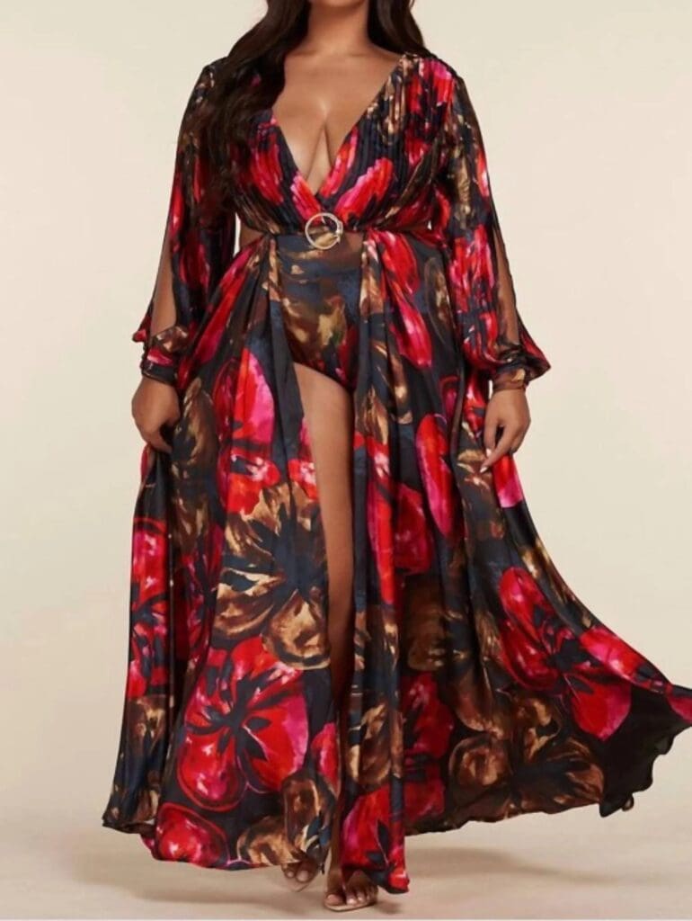 Woman wearing L’ATISTE maxi in vivid red and black florals is designed with a plunging V-neckline, long sleeves and a dramatic side slit.