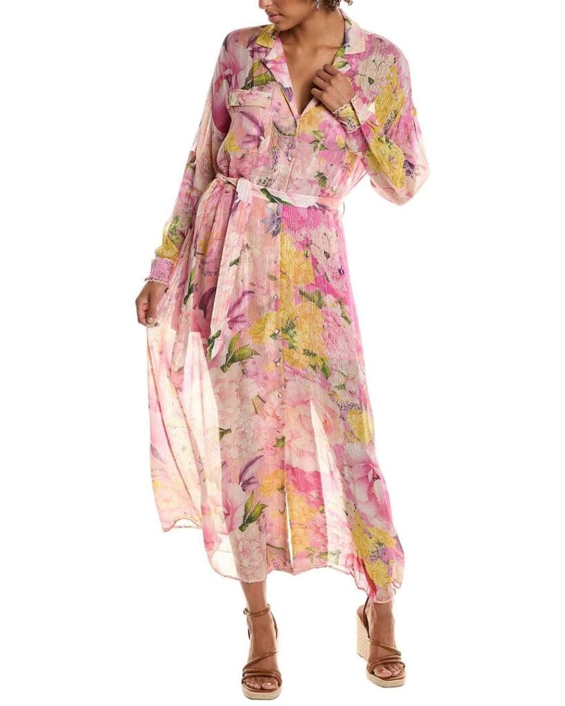 A woman wears a Rococo Sand maxi dress in a floral pink, green and yellow print blends soft pastels with bright pops of color with wrap-around wedges.