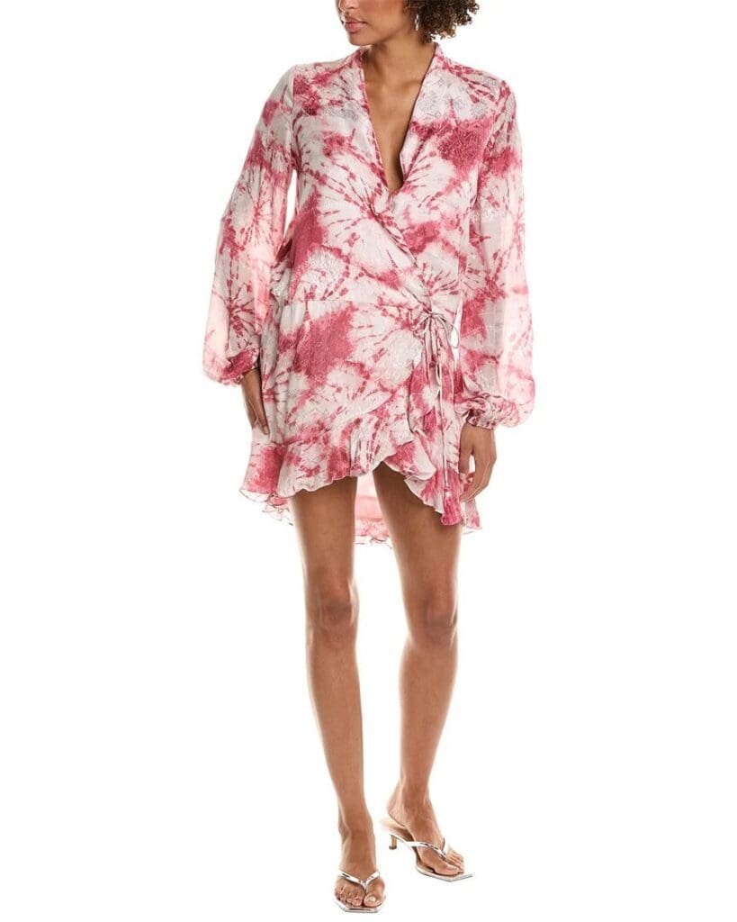 A woman wears a Rococo Sand mini dress in a pink-and-white tie-dye print with silver kitten heels.