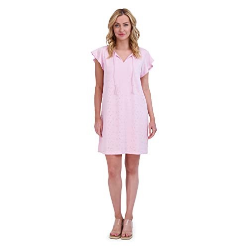 A blonde woman wears a just-abovethe- knee-length Stella Parker sundress in soft pink with clear kitten sandals.