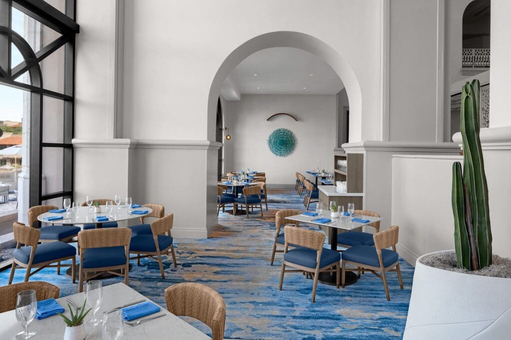 The open area La Luz at The Westin La Paloma Resort & Spa with tables and expansive windows.