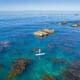An aerial view of a Laguna Beach reef with a paddle boarder.