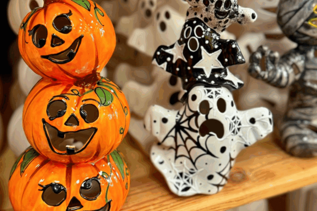 Stacked pumpkins hand-painted next to a handpainted ghost and mummy from As You Wish Pottery at Desert Ridge Marketplace.