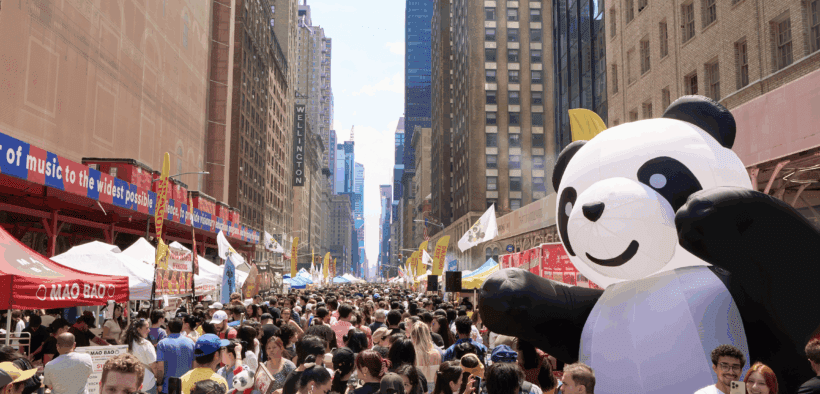 A large gathering of people in a Downtown city, celebrating Panda Fest.