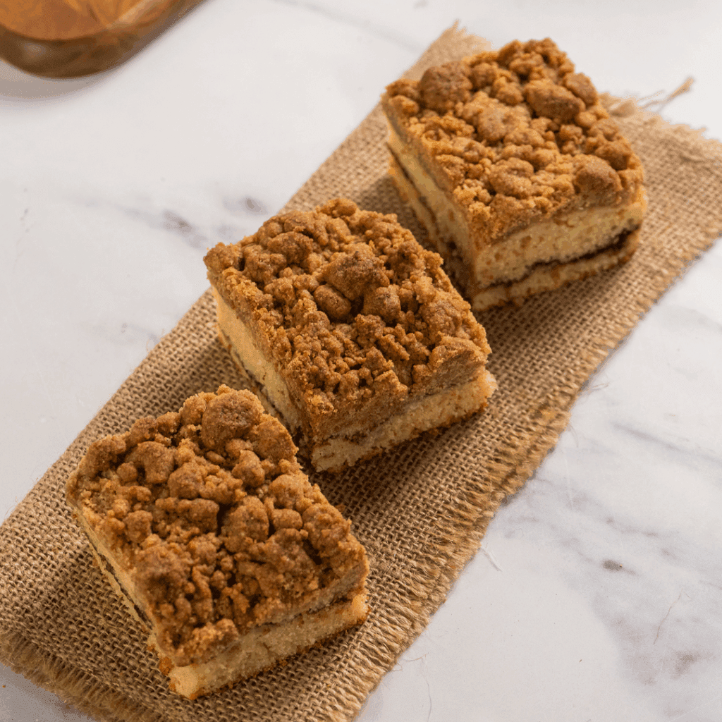 A row of three pumpkin praline coffee cake squares on a strip of burlap at Moon Raccoon Baking Company.