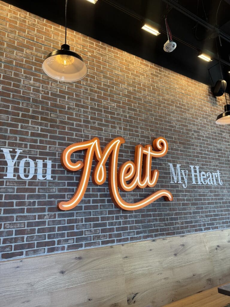 An indoor sign against a brick wall that says "You Melt My Heart" at The Melt at Novus Innovation Corridor.