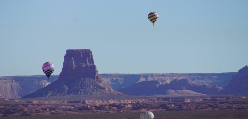 Three hot air balloons in various positions in the sky in Page, Arizona, for the annual Balloon Regatta.