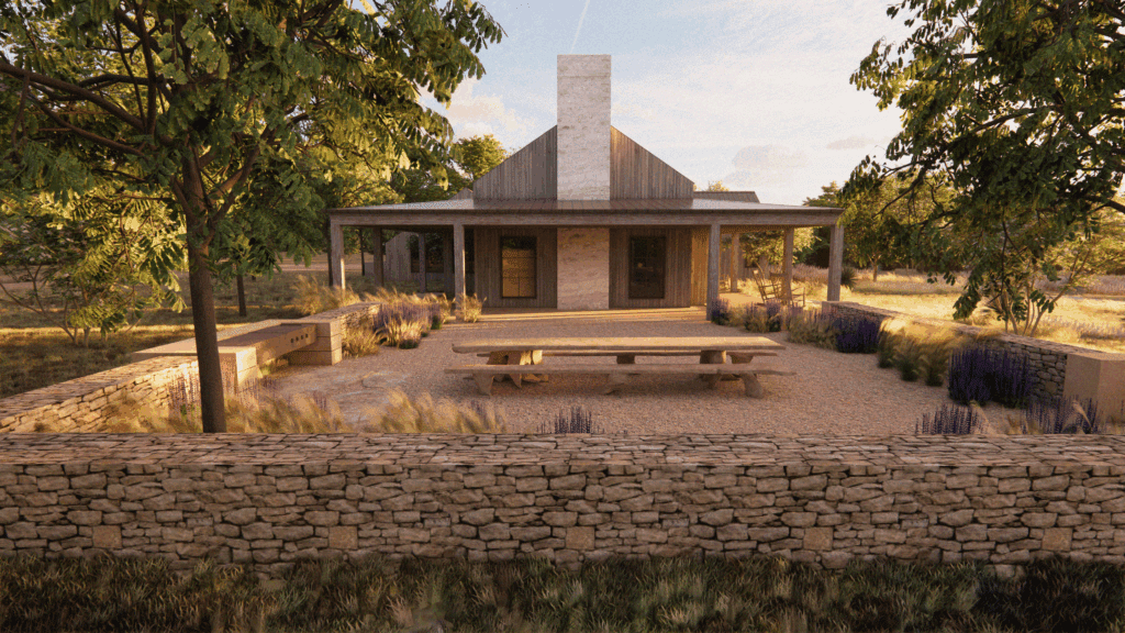 The exterior of one of Hideaway Round Top's casita courtyards surrounded by trees and a rock fence. 