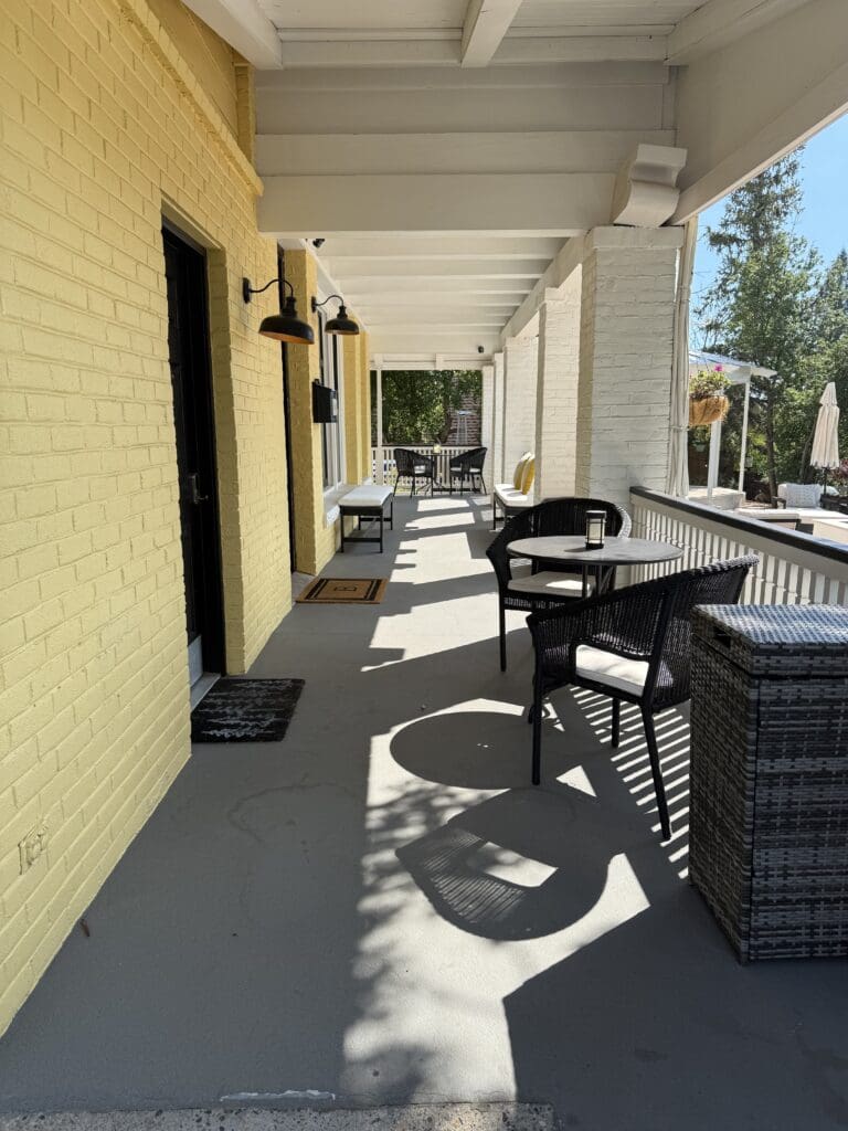 The Bespoke Inn's entrance porch with wicker seating and coffee tables. 