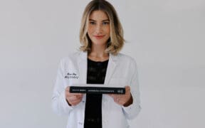 Marissa Adbo of Aesthetic IQ Clinic holds a book in her hands.