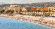Coastal landscape with people resting on the beach along the Promenade des Anglais in Nice. French Riviera, France.