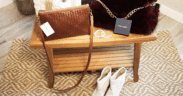 A leather woven purse, Arlo fur back with gold chain, otther bracelts and leather boots in a bright room.