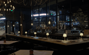 A hanging light hovers above a dimly lit single-diner square table at Humble Bistro.