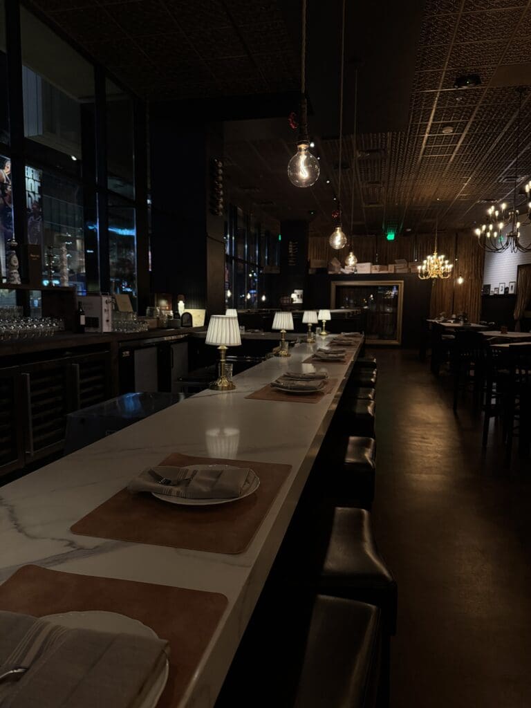 A single-diner table with place settings and low lamp lighting at Humble Bistro in Downtown Phoenix. 
