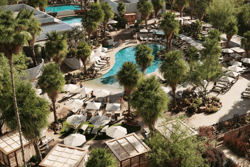 A birds-eye view of a pool, palm trees, cabanas, loungers and umbrellas at Kimpton Miralina Resort in Paradise Valley.