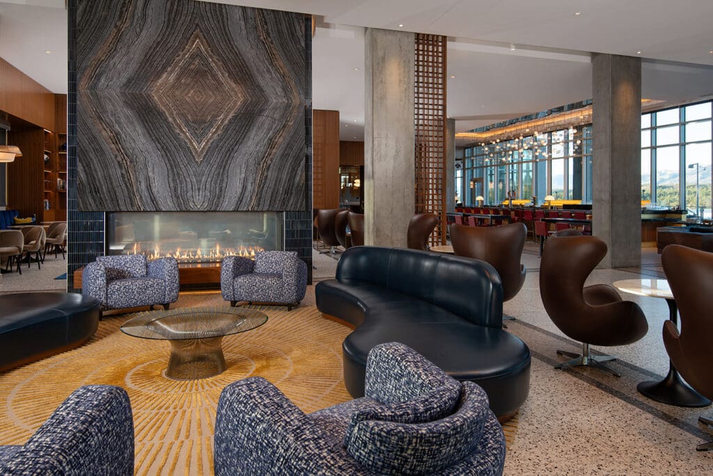 The lobby of Hotel Polaris in Colorado Springs with a fire in the fireplace and modern seating. 