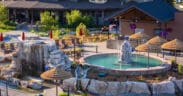 The Springs Resort lodge building with two geothermal pools in front with steam rising.