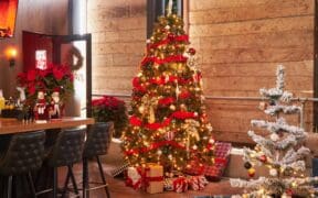 Two decorated Christmas trees with presents underneath at Culinary Drop Out in Phoenix.