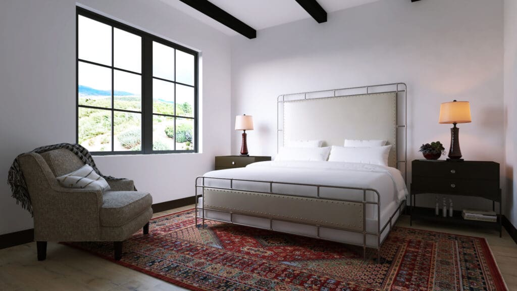 A queen bed and side table with native-looking rug and comfy arm chair covered in a blanket at the Washington Inn, Santa Fe.