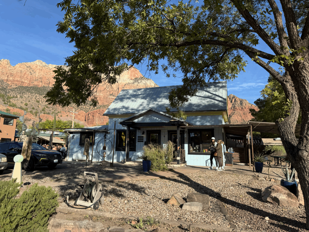 Two people stand outside of Dry Creek Coffee Company in Springdale, Utah.