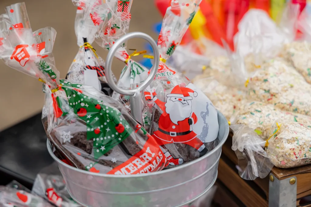 A galvanized bucket full of bagged holiday treats next to backs of Rice Krispie treats at the Peppermint Lane Holiday Market in Downtown Corpus Christi.